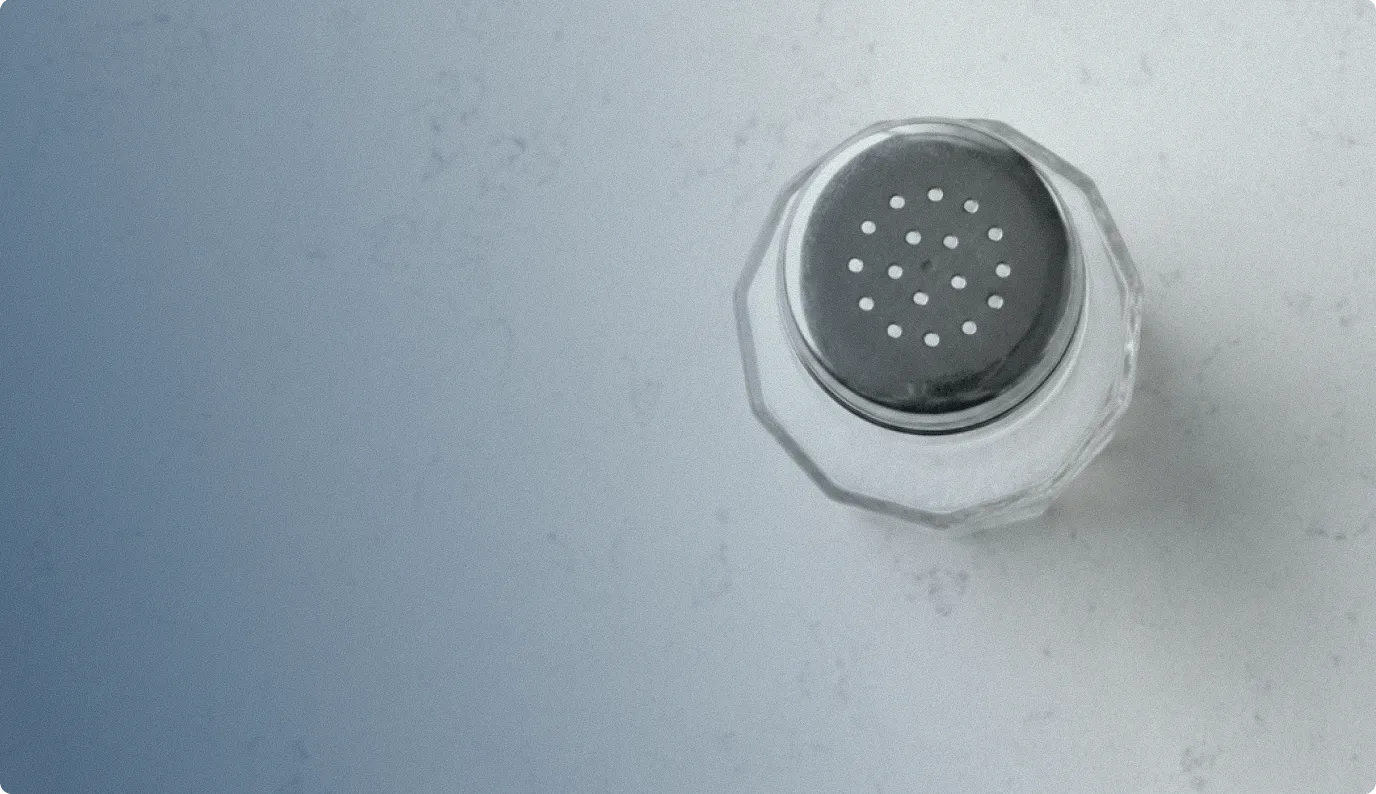 A salt shaker on a marble countertop